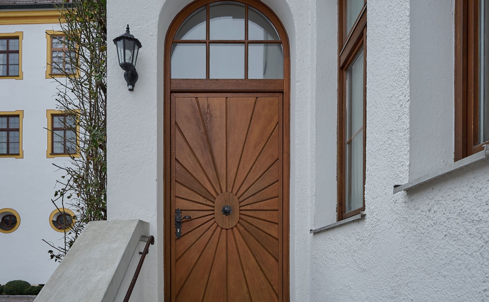 Eingangstüre aus Holz mit Oberlicht und Rundbogen